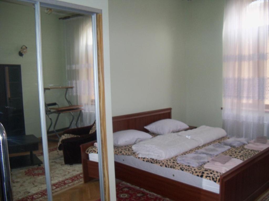 a bedroom with a bed and a mirror at Apartment Roman in Lviv