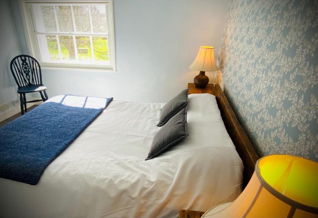 a bedroom with a bed with a lamp and a window at Pass the Keys Superbly Located Handsome Georgian Townhouse in Shrewsbury