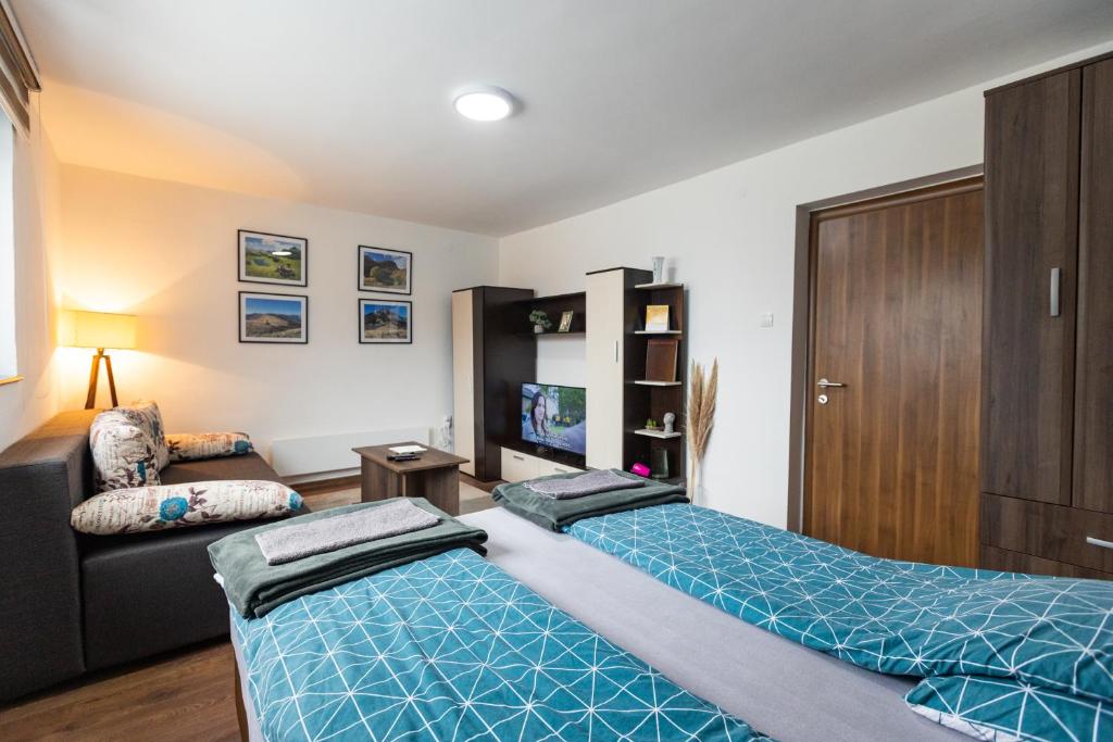 - un salon avec deux lits et un canapé dans l'établissement Apartman Zelengora, à Tjentište