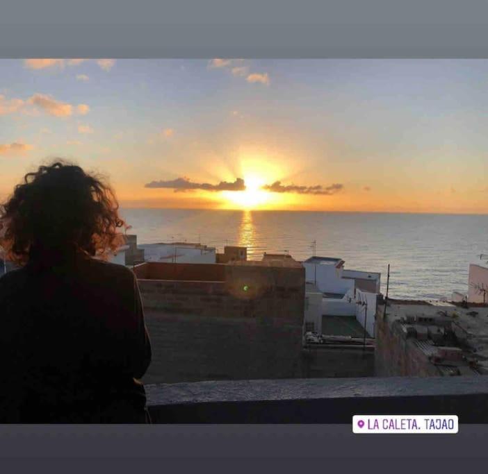 eine Person mit Blick auf den Sonnenuntergang über dem Meer in der Unterkunft CASA NENO in La Mareta