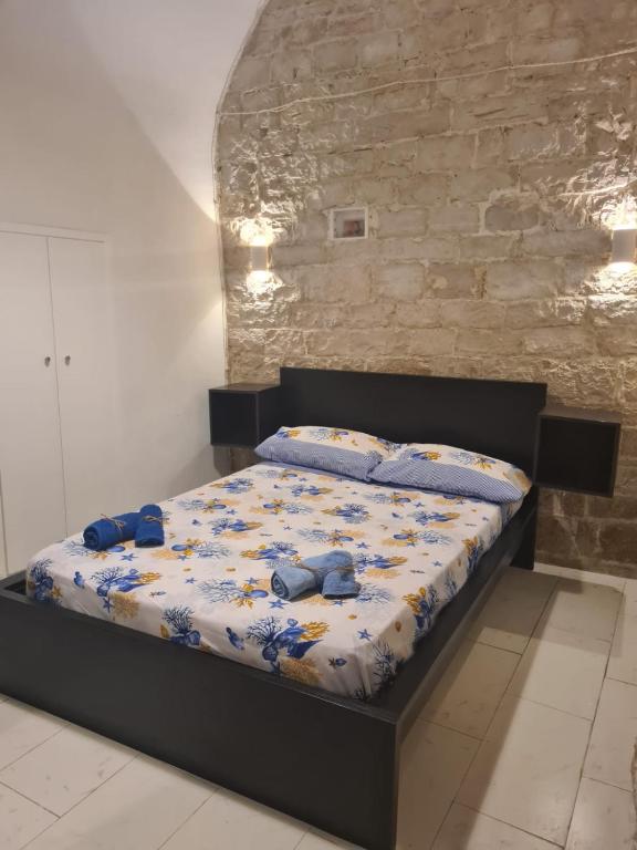 a bed in a room with two blue shoes on it at La Cattedrale in Bisceglie