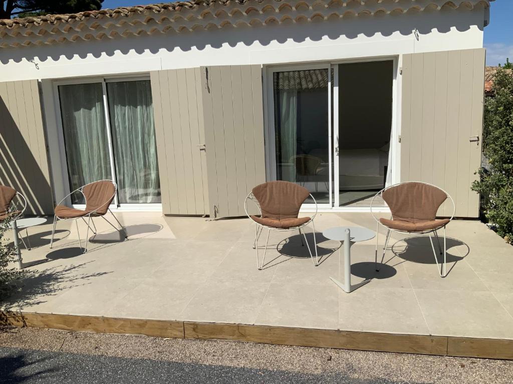 a group of chairs and a table on a patio at Le Mas de la Dame in Saint-Tropez