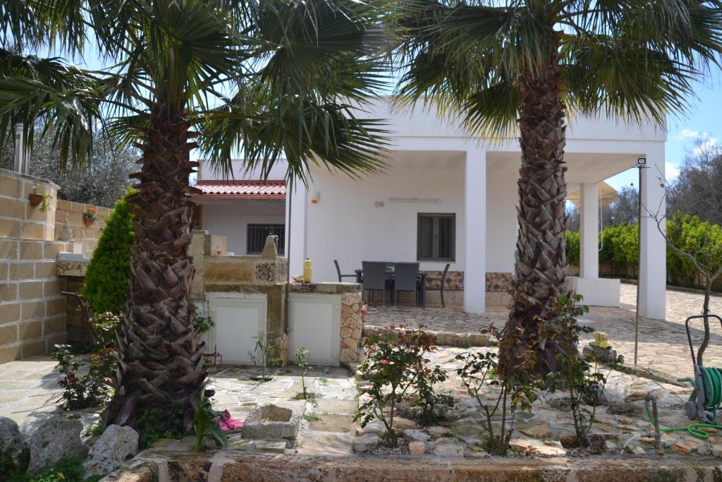 une maison avec deux palmiers dans la cour dans l'établissement VILLA DAVIDE, à Tiggiano