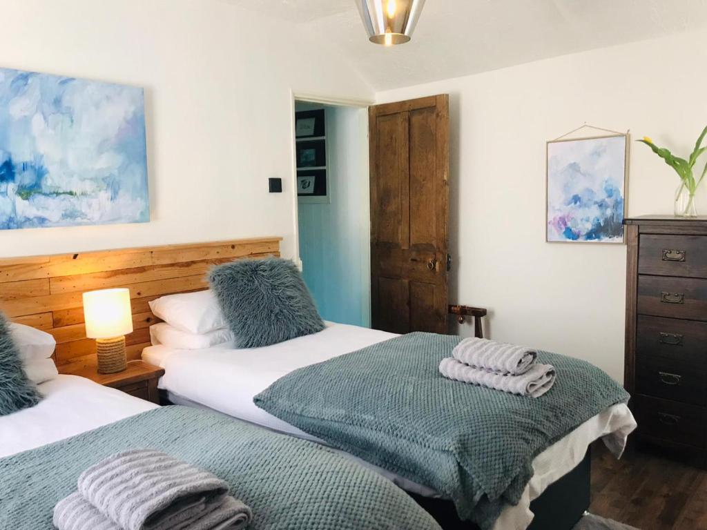 a bedroom with two beds with towels on them at Market House, Mousehole in Mousehole