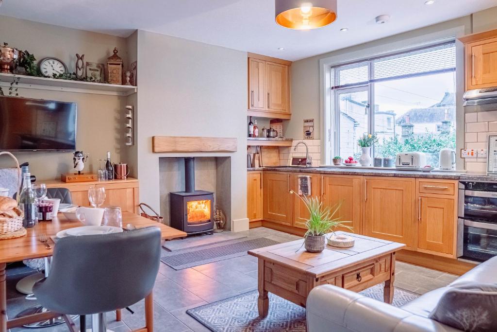 a kitchen and living room with a table and a fireplace at Cottage Apartment in Dunblane