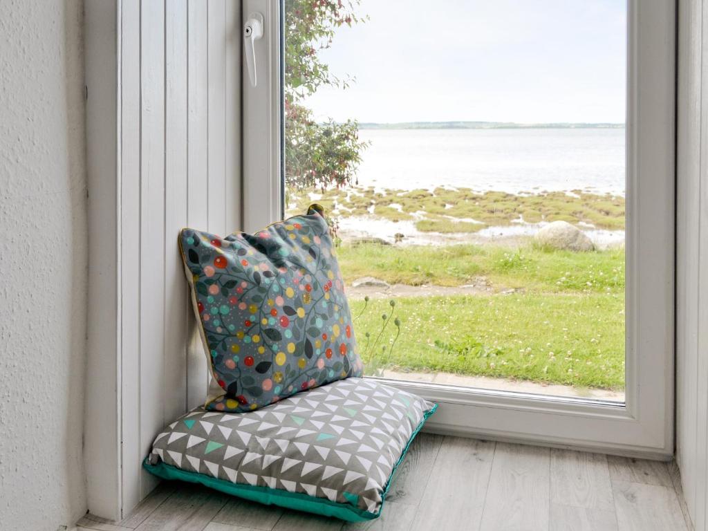 a pillow sitting in front of a window at Shore Cottage in Carsluith