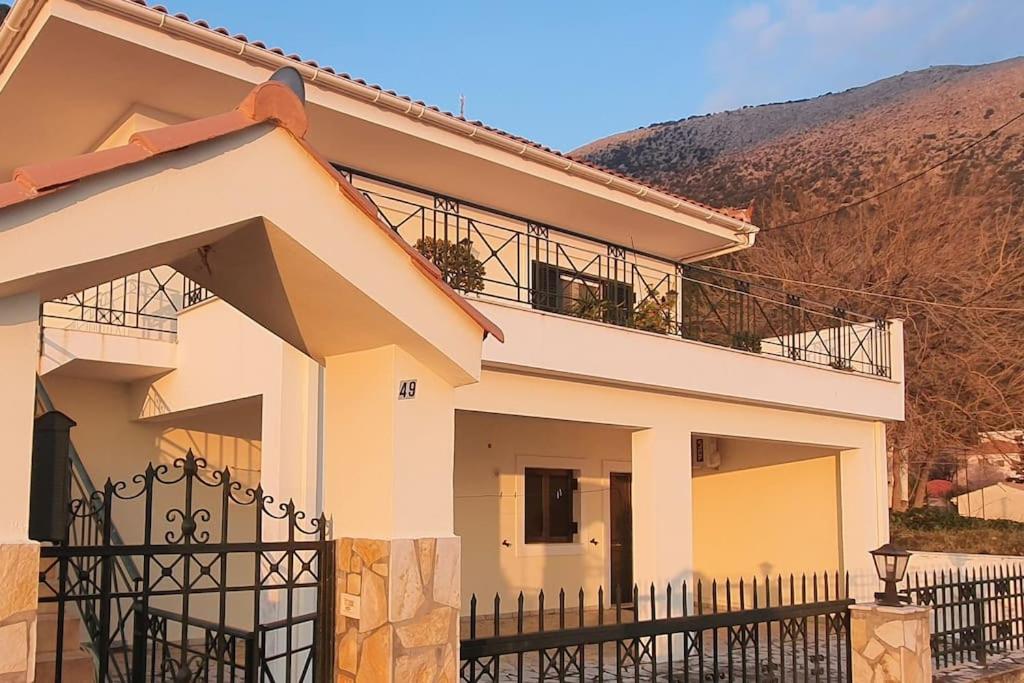 dom z czarnym płotem przed nim w obiekcie Villa Dimitra - Amazing sea view w mieście Poros