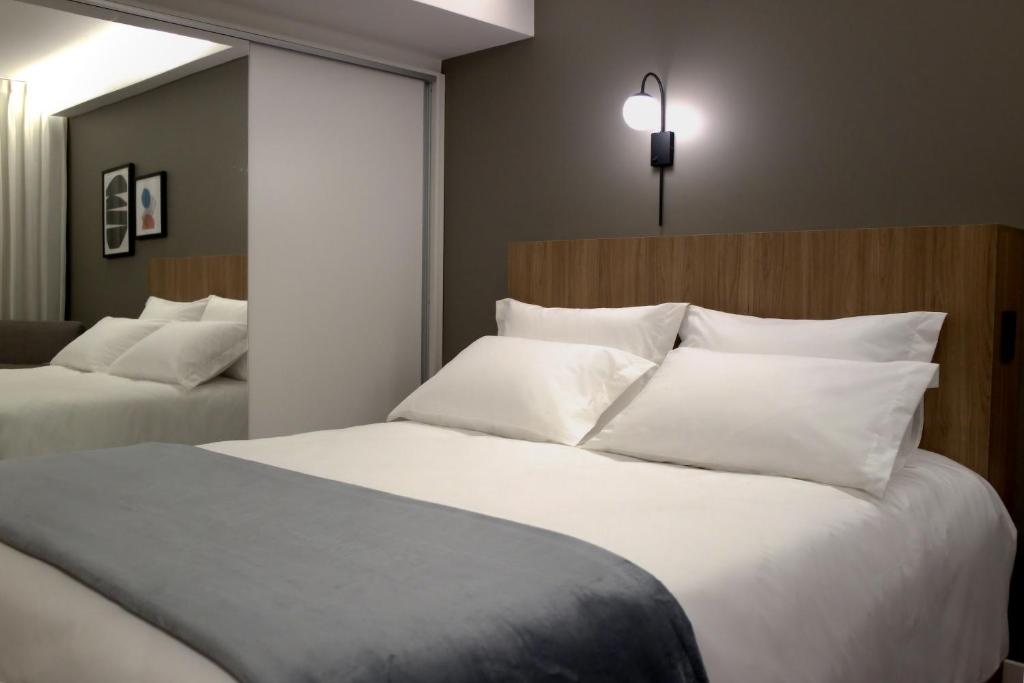 um quarto de hotel com duas camas com almofadas brancas em HIGI HOTEL SÃO PAULO em São Paulo