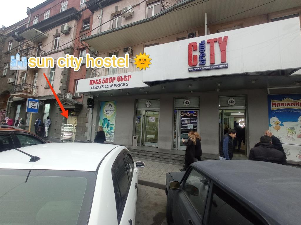 a sun city hospital building with people walking in front of it at Sun city hostel in Yerevan