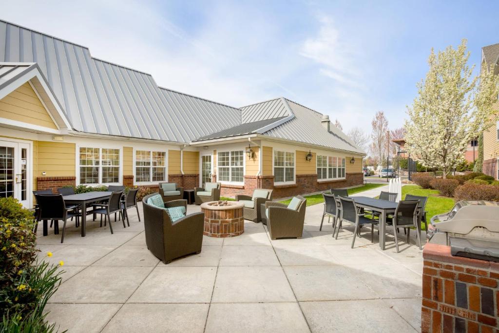 un patio con mesas y sillas frente a una casa en Residence Inn Spokane East Valley, en Spokane Valley