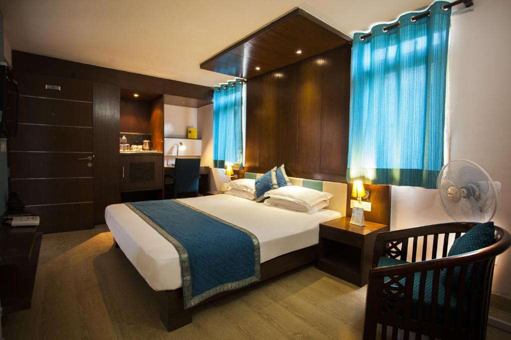 una camera da letto con un grande letto con tende blu di Flag House Resort a Jūnga