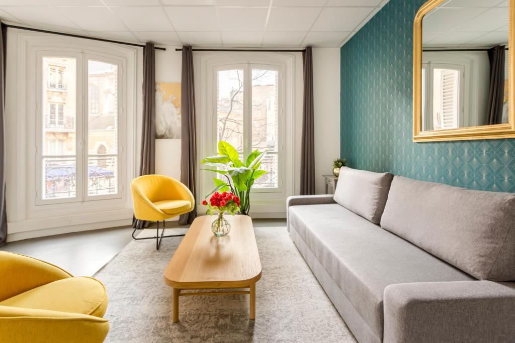 ein Wohnzimmer mit einem Sofa und einem Tisch in der Unterkunft Cosy 3 bedrooms apartment - Le Marais in Paris