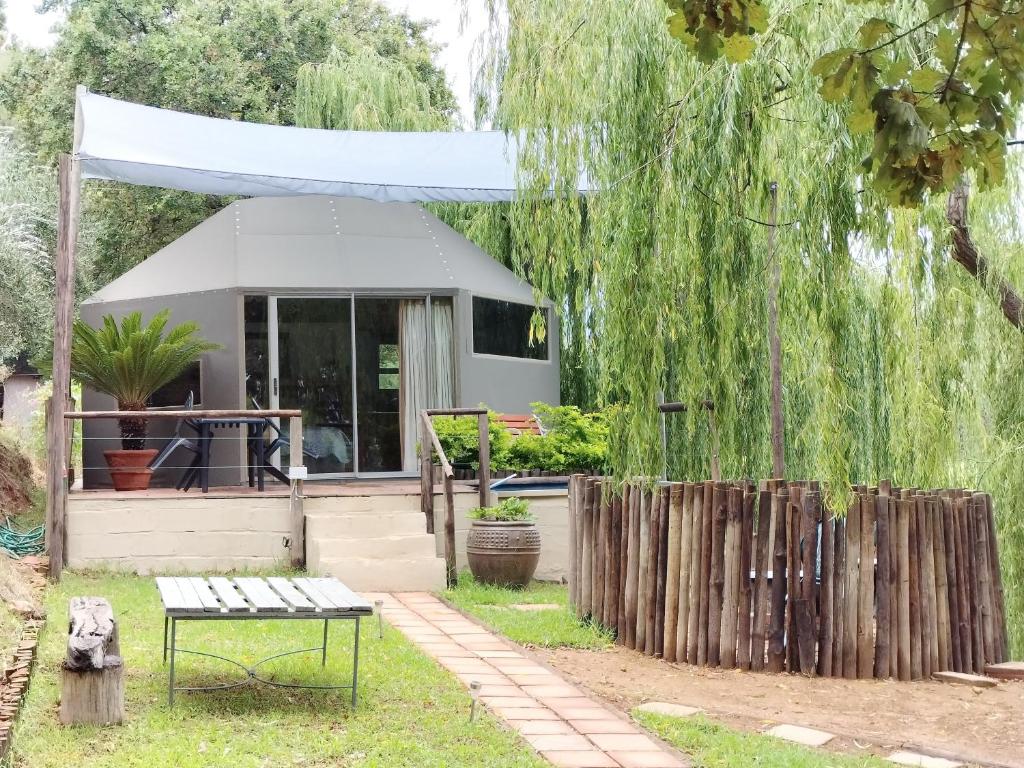 a bench in front of a building with a tent at Glamping at The Well in Franschhoek in Franschhoek