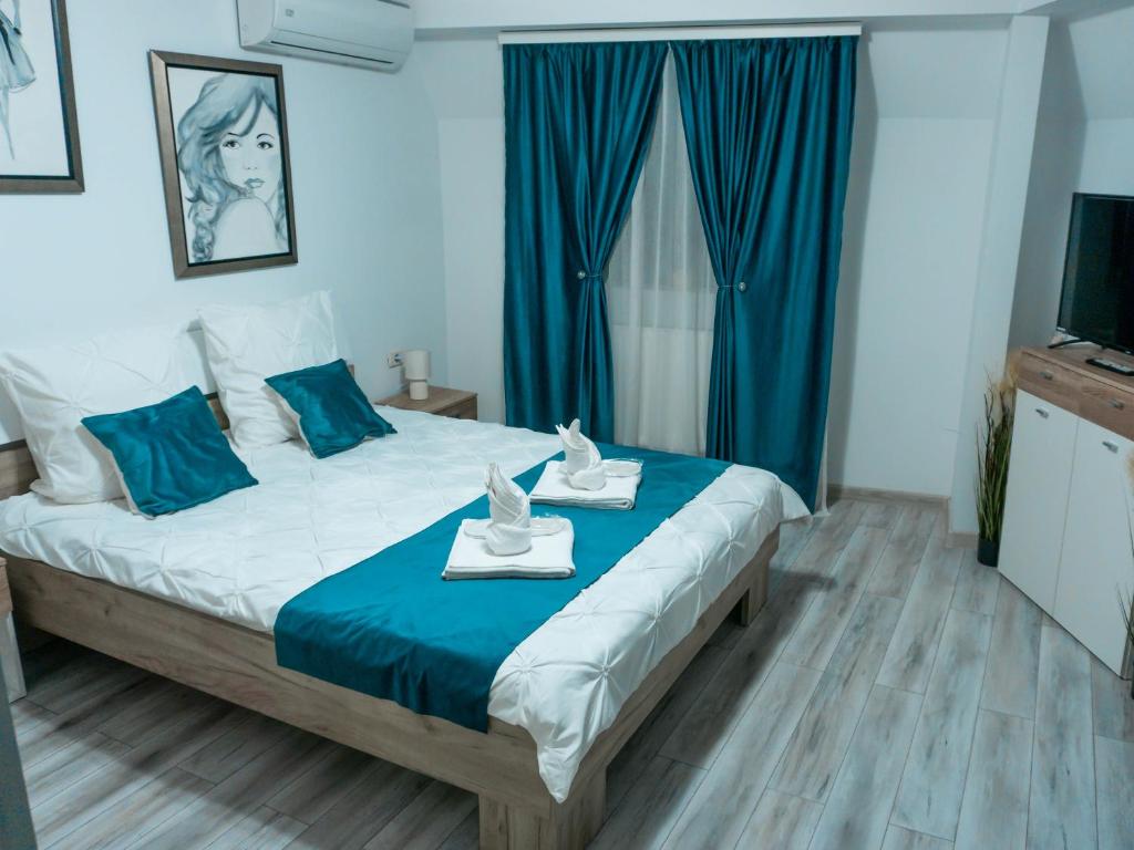 een slaapkamer met een groot bed en blauwe gordijnen bij Comfortable Apartment Unirii Square - CAL3B in Boekarest