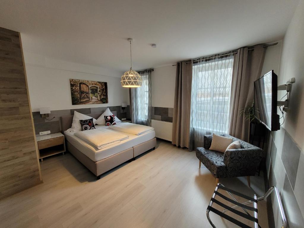 een slaapkamer met een bed en een stoel erin bij Hotel MoinMoin in Bad Bramstedt