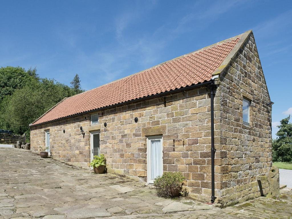 a small brick building with a red roof at North Range in Castleton