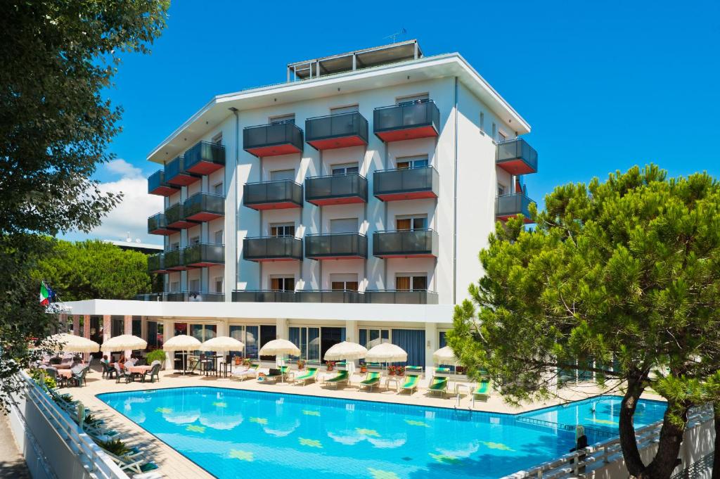 un hotel con piscina frente a él en Hotel Gimm, en Bibione