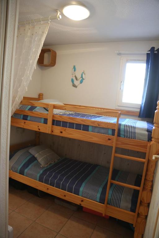 2 Etagenbetten in einem Zimmer mit Fenster in der Unterkunft Maldives YourHostHelper in Saint-Cyr-sur-Mer