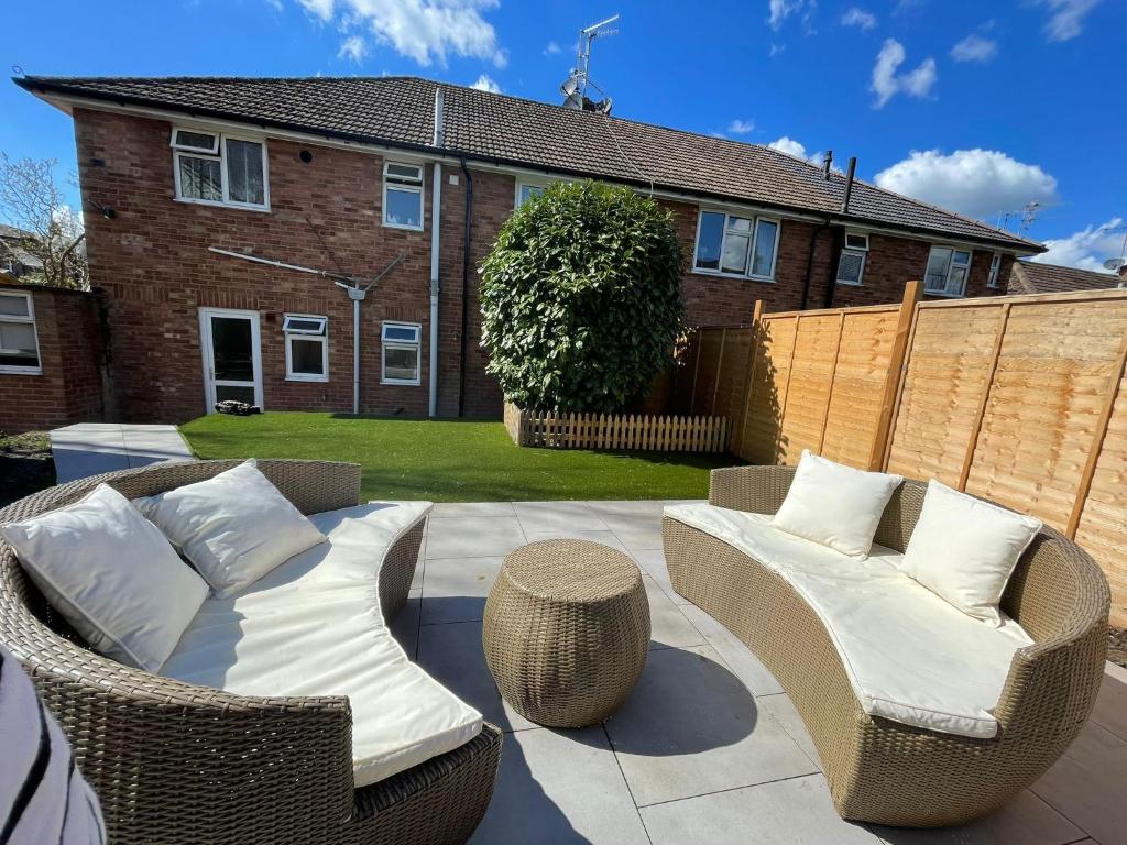 a patio with two wicker chairs and a table at Lovely 2 bedroom apartment with a garden in Royal Tunbridge Wells