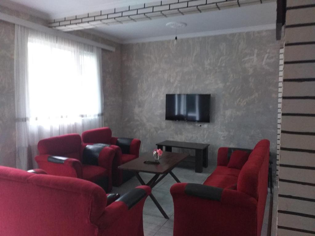 a waiting room with red chairs and a tv at Family Hotel "Big House" in Kobuleti