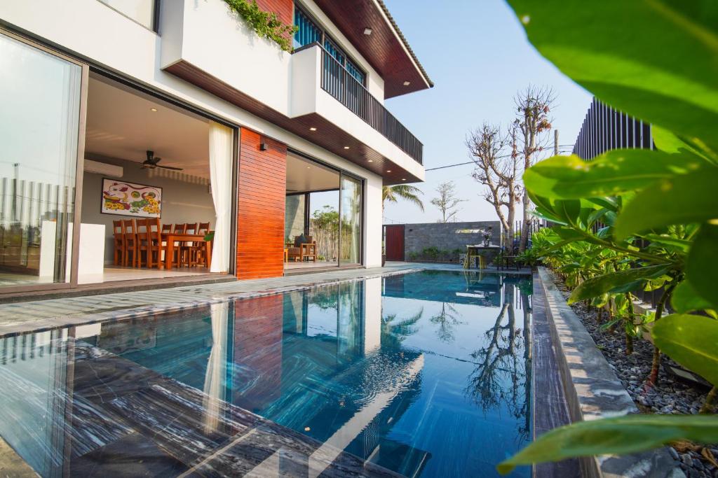 an image of a swimming pool in front of a house at Hola Villa 2 by Ovui in Hiếu Nhơn