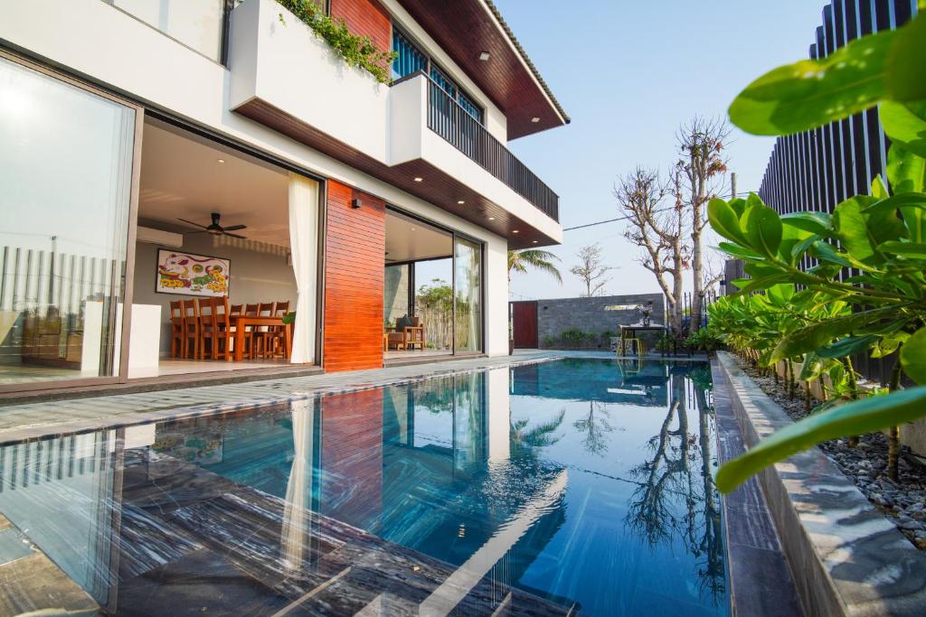 an image of a swimming pool in front of a house at Hola Villa 1 by Ovui in Hoi An
