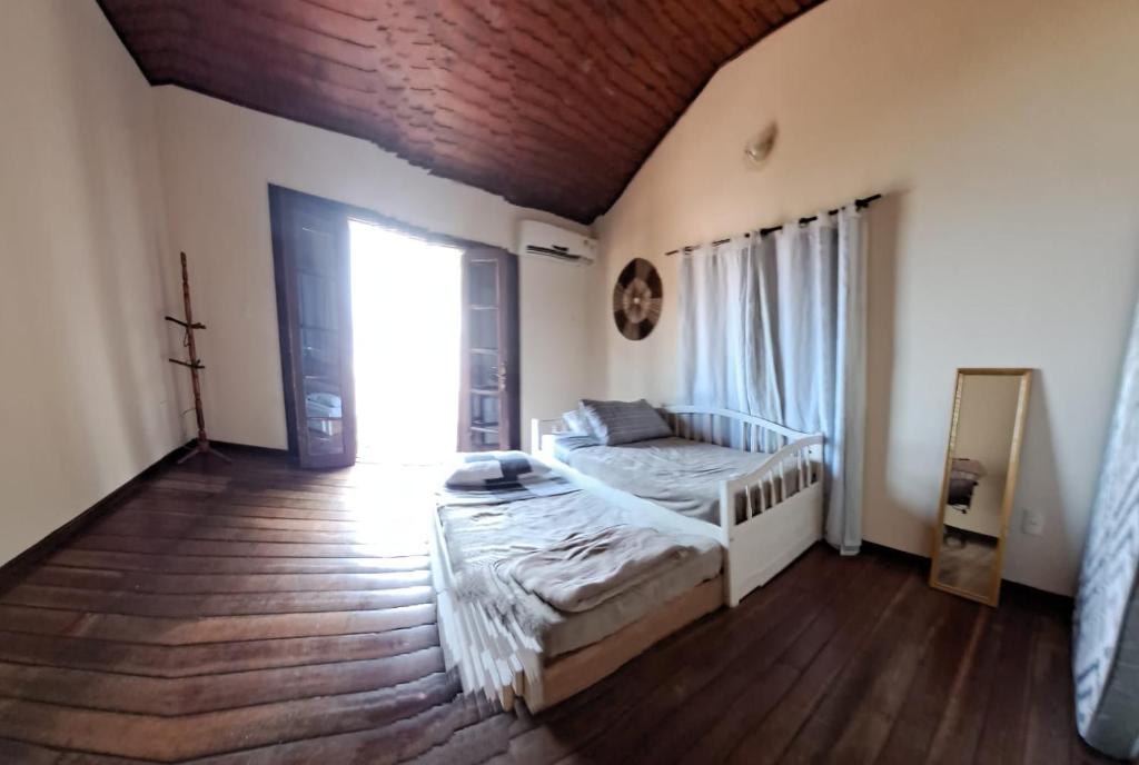 um quarto com uma cama e uma grande janela em Mansão Rústica na Joatinga Piscina Fundo Infinito no Rio de Janeiro
