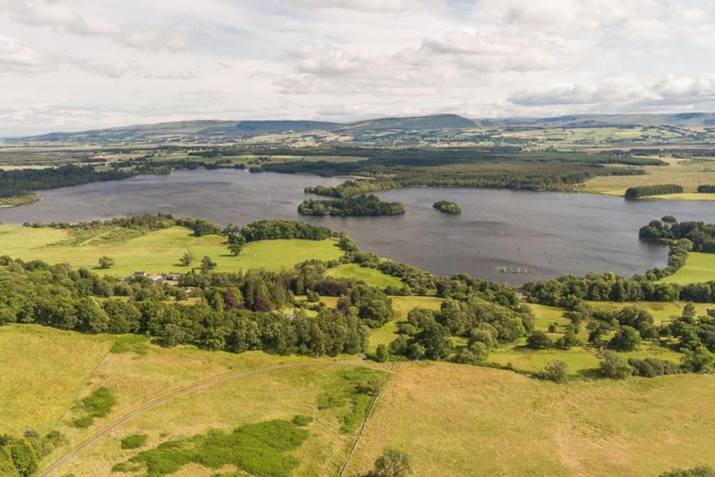 an aerial view of a lake in a field at The Stable - cottage with a spectacular lake view in Port of Menteith