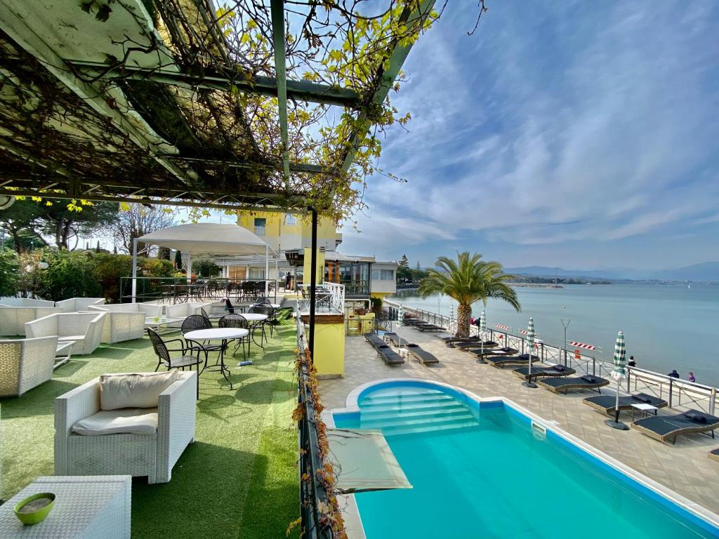 un complejo con piscina y vistas al agua en Hotel Estée en Desenzano del Garda