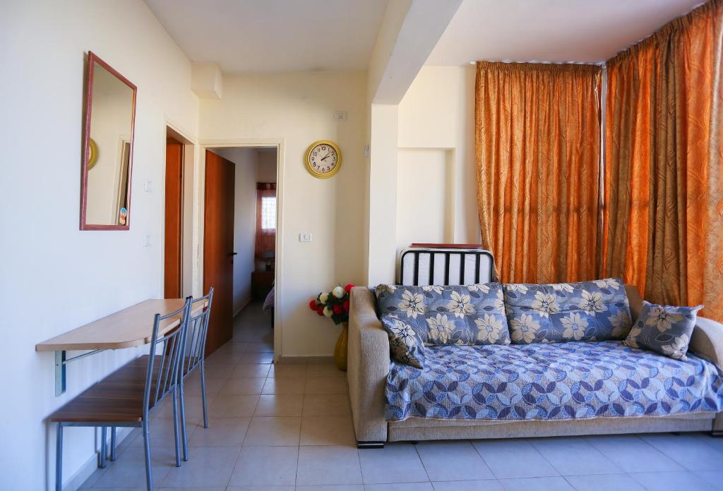 ein Wohnzimmer mit einem Sofa und einem Tisch in der Unterkunft Apartments Petah Tiqwa in Petach Tikwa