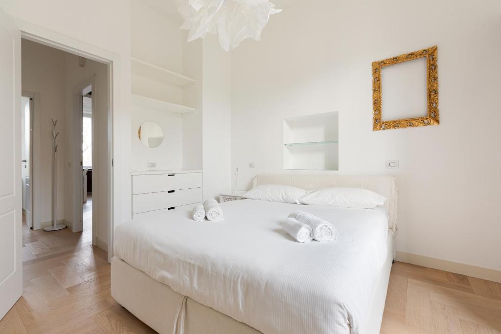 um quarto branco com uma cama branca e um espelho em Milano- Darsena and Navigli Area! Cozy APT! em Milão