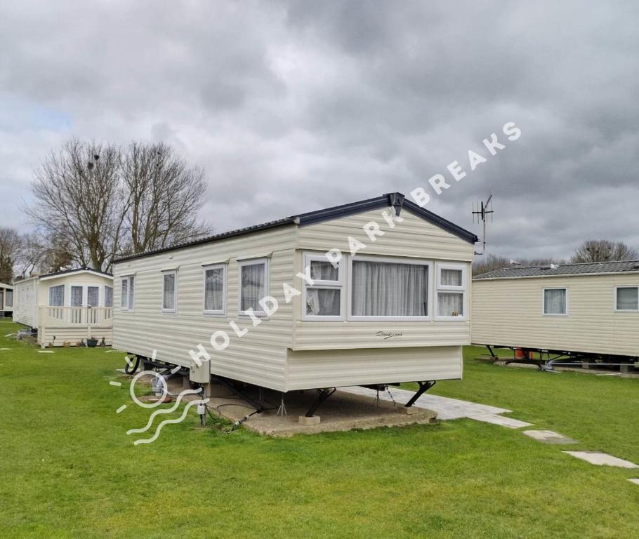 a white tiny house on a trailer in a field at Cosy 2 bed @ Seal Bay, Selsey in Selsey