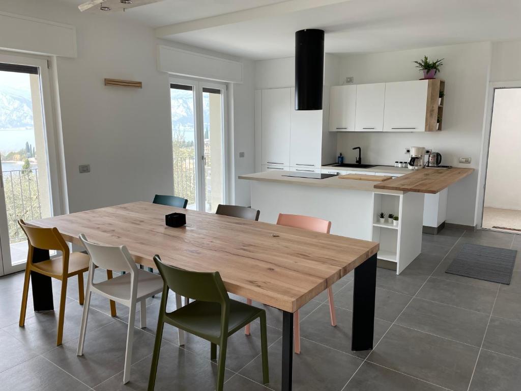 Una cocina y un comedor con mesa y sillas de madera. en Cochetto's House in Malcesine, en Malcesine