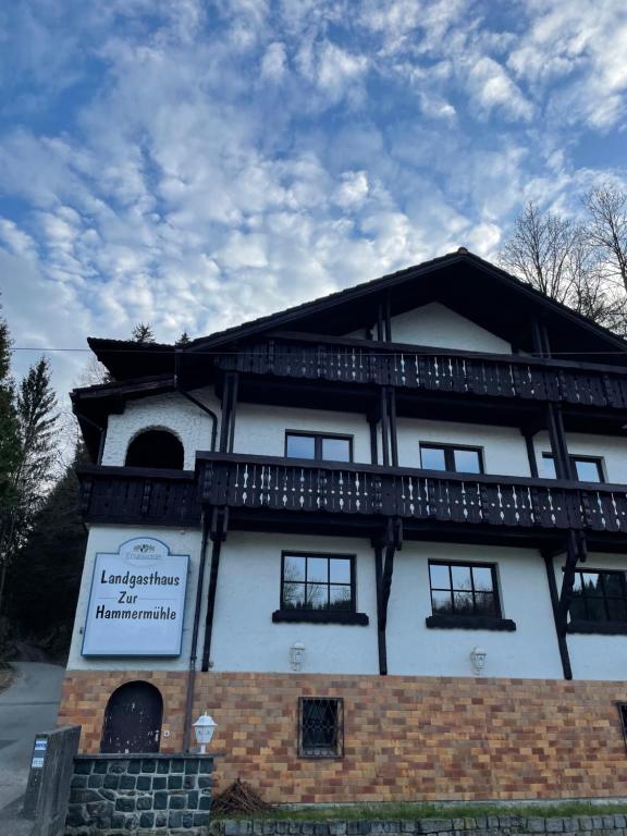 a building with a sign on the side of it at Pension zur Hammermühle in Wallenfels