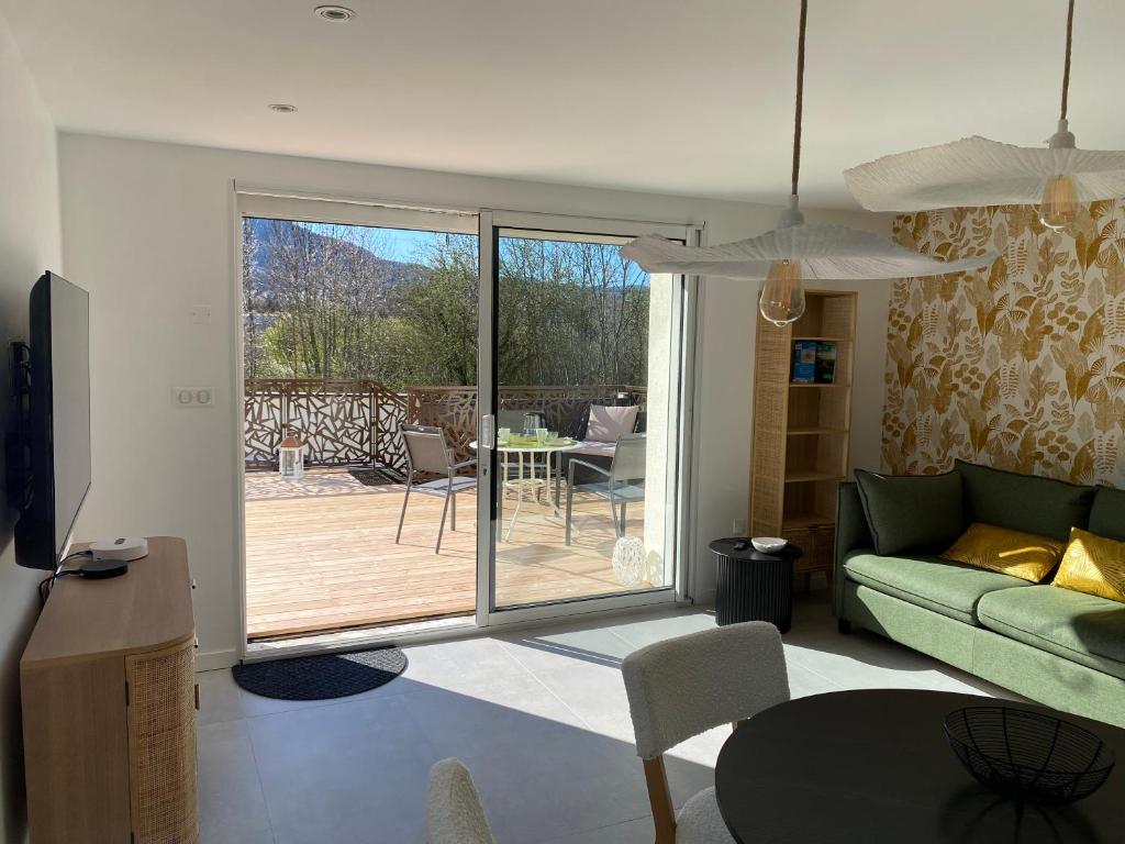 a living room with a couch and a patio at "Luci" proche du Zenith, Arténium Ceyrat, Auvergne, parking privé , in Beaumont