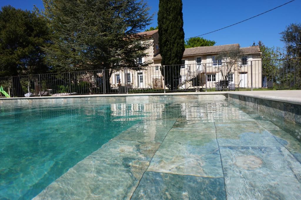 a swimming pool in front of a house at Mas de la Roule, 4 studios, piscine chauffée, studio SPA, parc 2 ha, Pont d'Avignon à pied in Avignon
