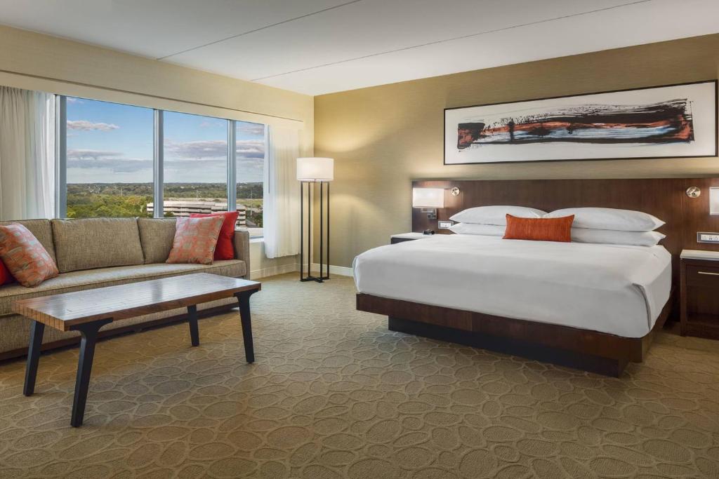 duży pokój hotelowy z łóżkiem i kanapą w obiekcie Delta Hotel Philadelphia Airport w Filadelfii