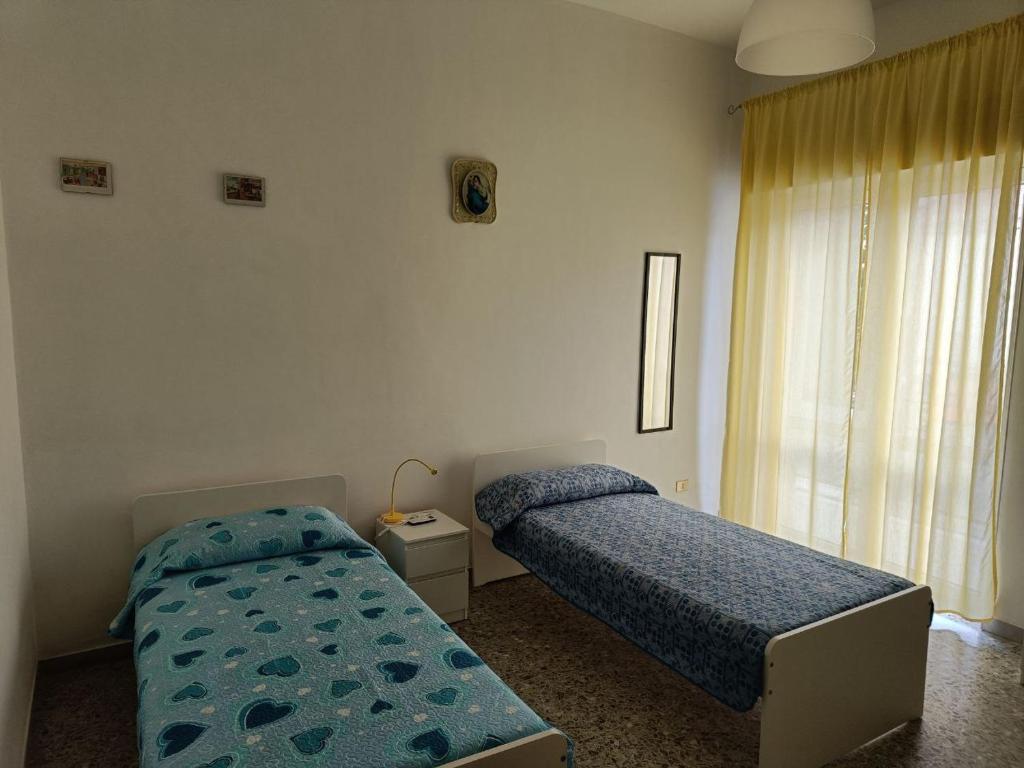 a bedroom with two beds and a window at Villa Carmela Capotosto in Mondragone