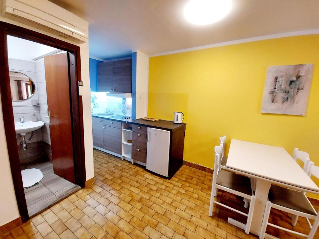 a kitchen with yellow walls and a table and a sink at Terra Apartments in Piran