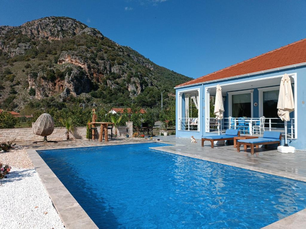 a house with a swimming pool with a mountain in the background at Villa Dionyssos in Dalyan