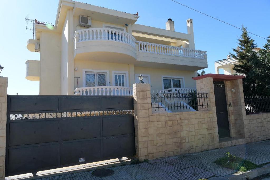 ein Haus mit einem schwarzen Tor und einem Zaun in der Unterkunft Loutraki view in Loutraki