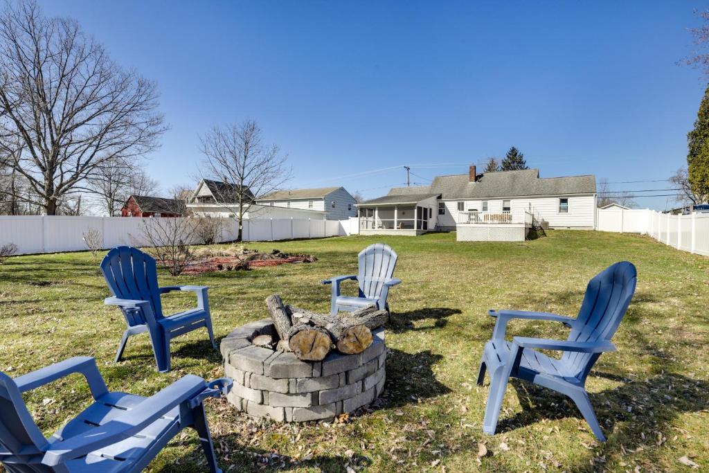 vier blauwe stoelen rond een vuurplaats in een tuin bij Massachusetts Vacation Rental with Deck in Easthampton