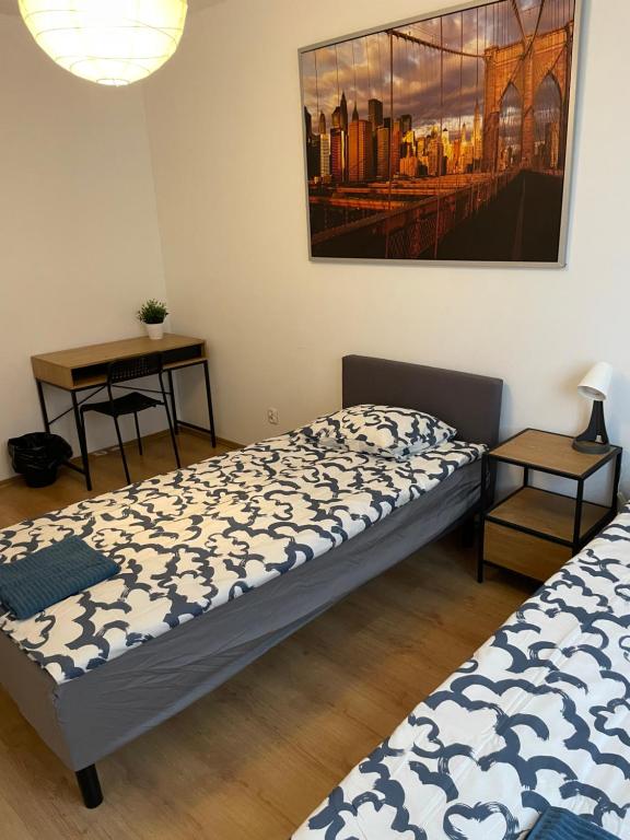 dwa łóżka w pokoju z obrazem na ścianie w obiekcie Pokoje KEN w Warszawie