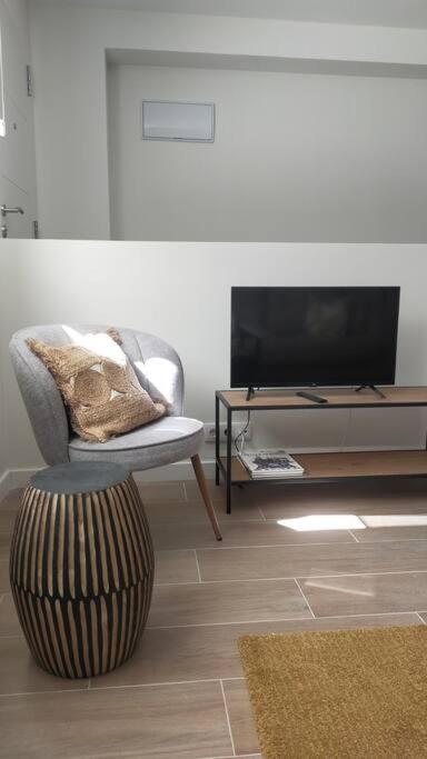 salon z krzesłem i telewizorem w obiekcie Apartamento Laurana w mieście Santander