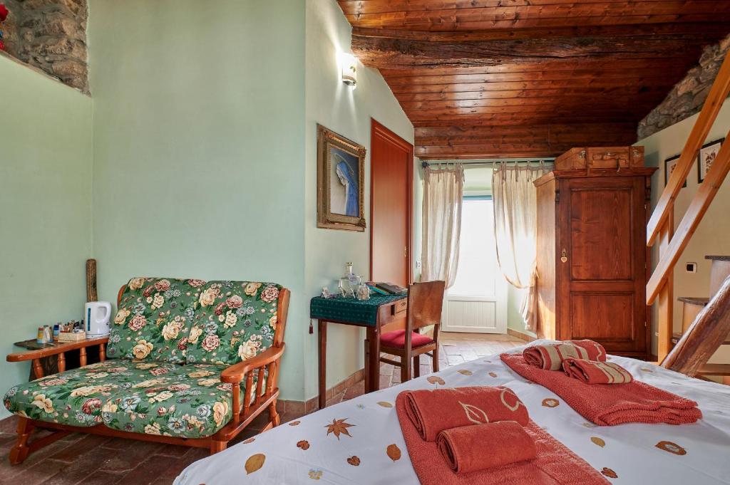 ein Schlafzimmer mit einem Bett, einem Sofa und einem Stuhl in der Unterkunft B&B Adelche in San Giovanni Bianco