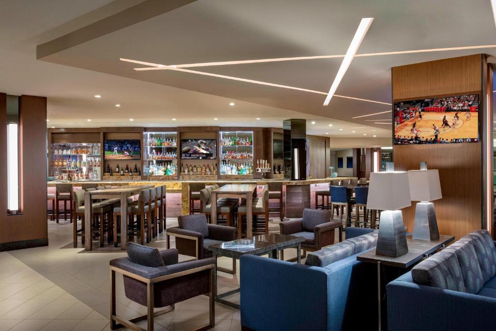 um restaurante com um bar com cadeiras e mesas azuis em Houston Airport Marriott at George Bush Intercontinental em Houston