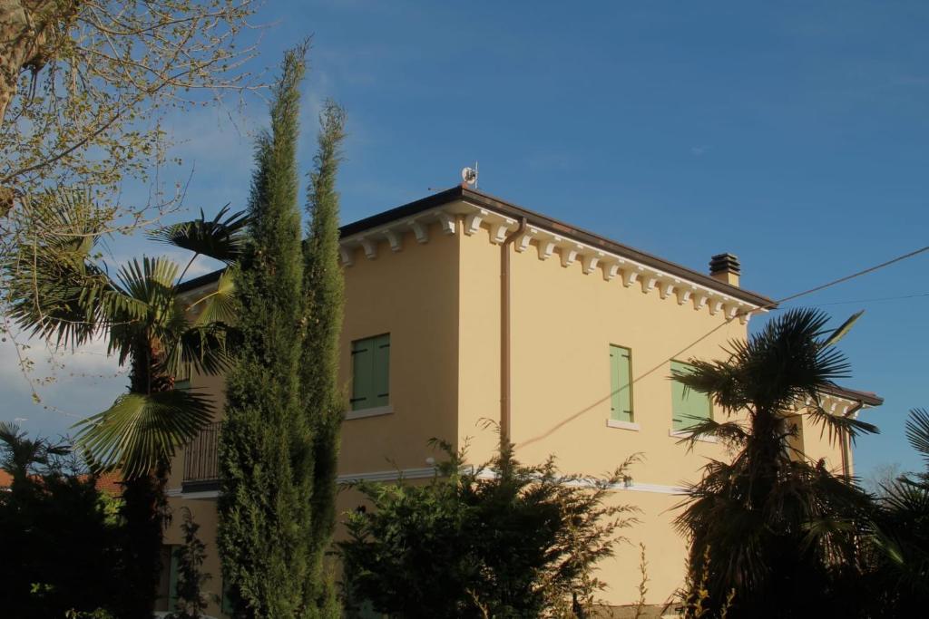 a building with palm trees in front of it at B&B Gasper in Cavalcaselle