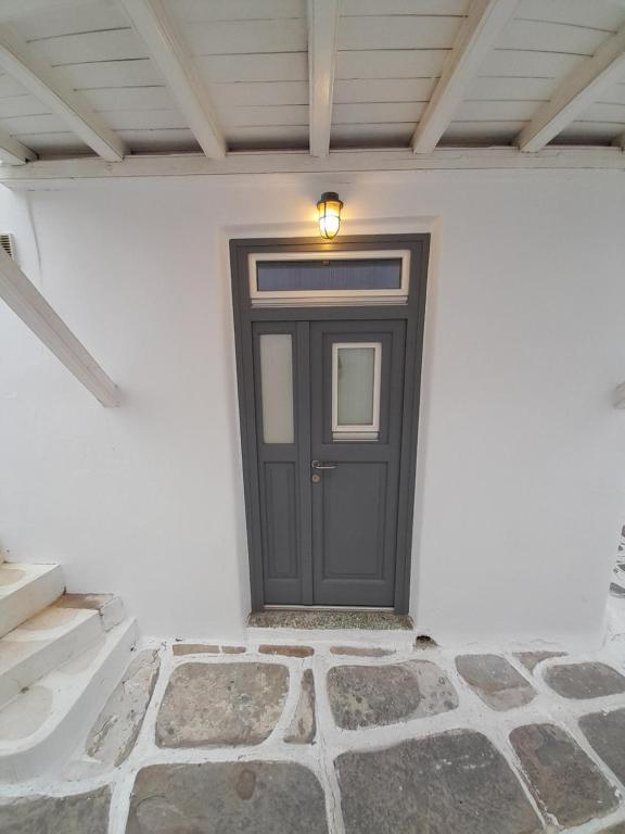 a black door in a white wall with a light at Terra Nova in Mýkonos City