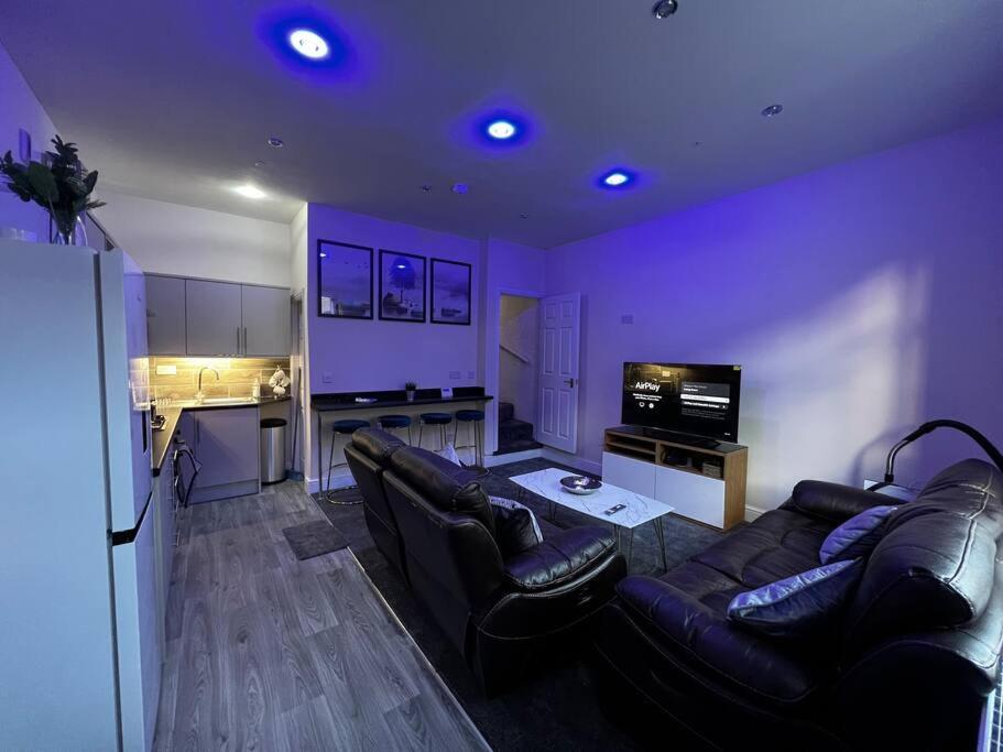 een woonkamer met banken en een keuken met paarse plafonds bij Luxe Loft Living: A Home Away From Home in Wibsey