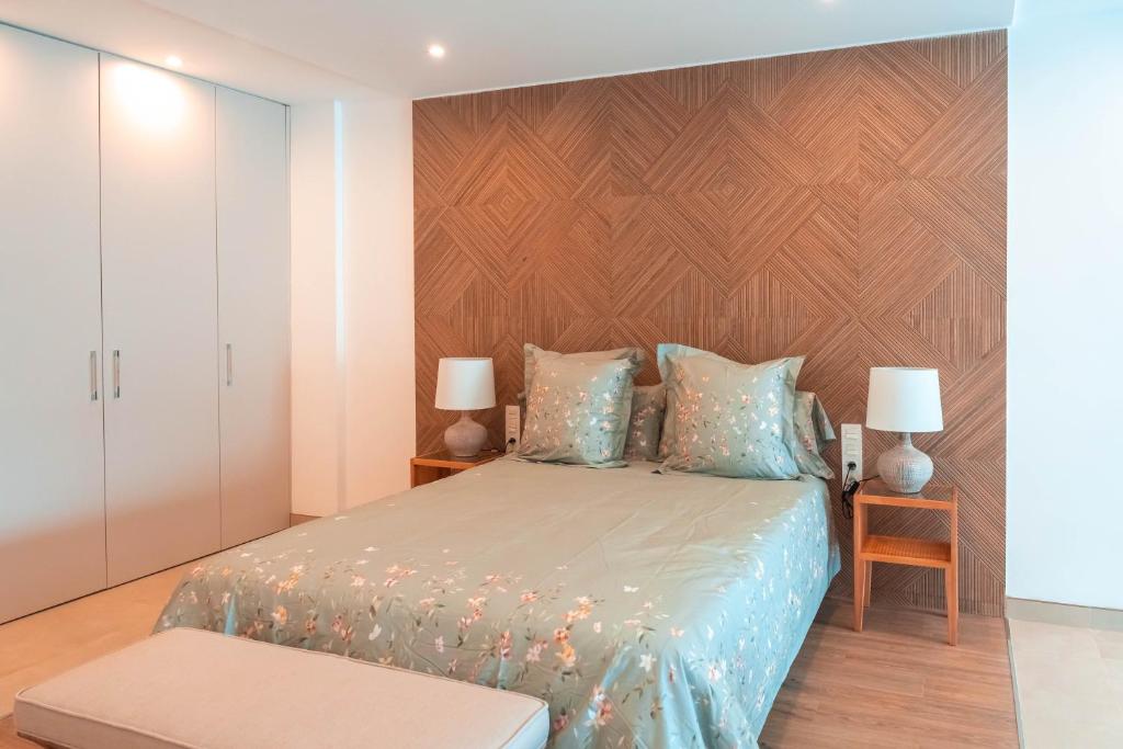 a bedroom with a bed and a wooden wall at Rooms & Suites Loft 2F Deluxe Edition Arrecife in Arrecife